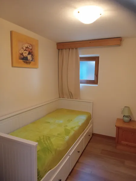 Das kleine Zimmer mit weißem Bett und Schubladen darunter