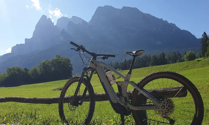 Mountainbike auf einer Wiese vor dem Schlern