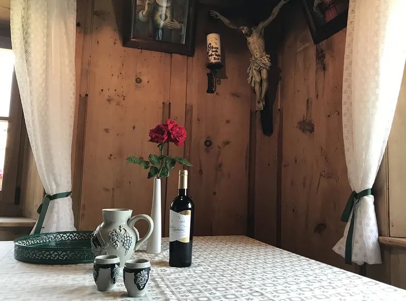 Stubenecke mit Krug, Wein und geschnitztem Kruzifix